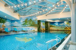 a large swimming pool in a hotel with a mural at Grand Phoenix Hotel Bac Ninh in Bắc Ninh