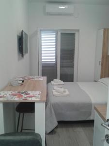 a hotel room with a bed and a table and a desk at Studio Antonio New in Zadar
