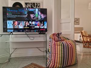 a flat screen tv sitting on a stand in a living room at La Maison Dorée in Giardini Naxos