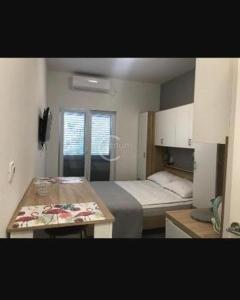 a small room with two beds and a table in it at Studio Antonio New in Zadar