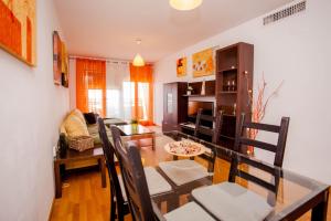 - une salle à manger et un salon avec une table et des chaises dans l'établissement Apartamento Teatinos, à Malaga