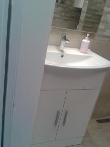 La salle de bains est pourvue d'un lavabo blanc et d'un miroir. dans l'établissement Studio Antonio New, à Zadar