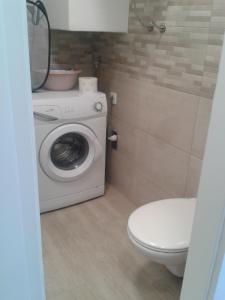a bathroom with a washing machine and a toilet at Studio Antonio New in Zadar