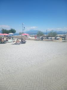 een groep mensen op het strand met parasols bij MARIANGELA in Desenzano del Garda