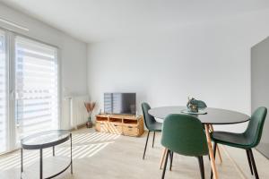 a dining room with a table and green chairs at J.Mo Home - Idéal famille - Calme - Au temps d'arrêt in Chessy