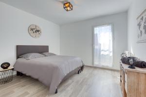 a white bedroom with a bed and a window at J.Mo Home - Idéal famille - Calme - Au temps d'arrêt in Chessy