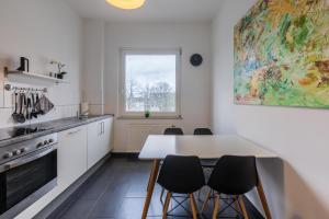 cocina con mesa, sillas y ventana en Glück Auf Appartements Rembrandtstraße Essen en Essen