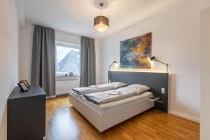 a bedroom with a bed and a window at Glück Auf Appartements Rembrandtstraße Essen in Essen