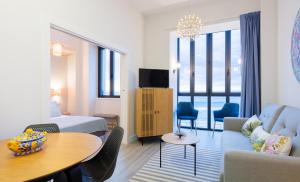 ein Hotelzimmer mit einem Bett, einem Tisch und Stühlen in der Unterkunft Apartamentos La Xiuca Playa in Gijón