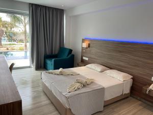a hotel room with a bed and a blue chair at Fedrania Gardens Hotel in Ayia Napa
