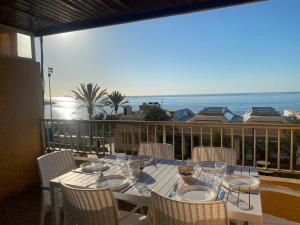 uma mesa numa varanda com vista para o oceano em Albamar frontline Beach apartment 3 bedrooms em Fuengirola