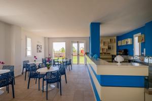 Una cocina y un comedor con mesas y sillas. en Tenuta Rocci Cerasoli, en Parabita