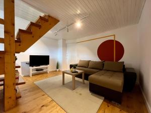 a living room with a couch and a tv at Sunset Apartment Kolašin in Kolašin