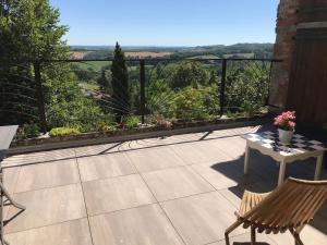 a balcony with a table and chairs and a view at Chambre chez l'habitant in Castelnau-de-Montmiral
