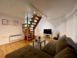 sala de estar con sofá y escalera de caracol en Sunset Apartment Kolašin en Kolašin
