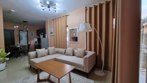 ein Wohnzimmer mit einem Sofa und einem Tisch in der Unterkunft Tagoloan 'Boutique' Apartments in Aplaya