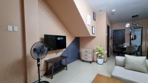 ein Wohnzimmer mit einem Sofa und einem Ventilator in der Unterkunft Tagoloan 'Boutique' Apartments in Aplaya