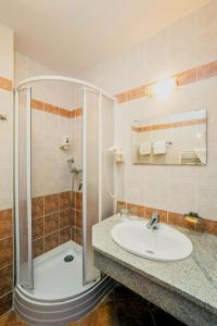 W łazience znajduje się umywalka i prysznic. w obiekcie Hungarospa Thermal Hotel w Hajduszoboszlo