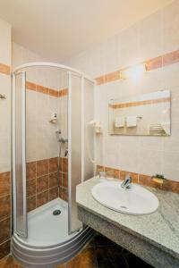 a bathroom with a sink and a shower at Hungarospa Thermal Hotel in Hajdúszoboszló