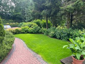 a garden with a brick path and green grass at Lapalice Holiday Home in Łapalice