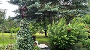 a bird house and a swan in a garden at Lapalice Holiday Home in Łapalice