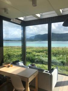 a living room with a table and a large window at Steigen Lodge Tiny house in Steigen