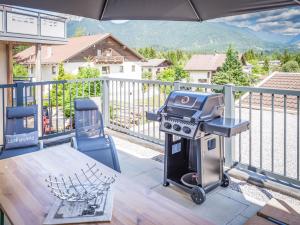 a bbq grill on a balcony with a table at Apartments Frauensee in Reutte