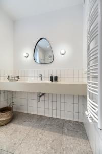 bagno con lavandino e specchio di Pure Apartment Sopot a Sopot