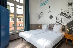 a bedroom with a bed and a large window at Stayokay Hostel Amsterdam Vondelpark in Amsterdam