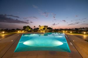 una gran piscina por la noche en Tenuta Rocci Cerasoli, en Parabita