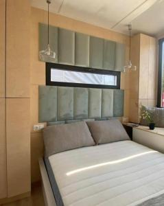 a bedroom with a large white bed with a window at Steigen Lodge Tiny house in Steigen