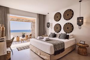a bedroom with a bed and a view of the ocean at Artemis Seaside Resort in Paliochori
