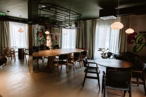 a dining room with tables and chairs and paintings on the walls at Hotel Septembar in Podgorica
