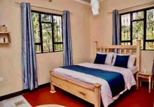 1 dormitorio con 1 cama con cortinas y ventanas azules en gemütlicher Bungalow x Garten & Terrasse x NETFLiX en Moshi