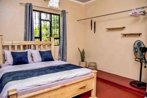 1 dormitorio con 1 cama, ventana y ventilador en gemütlicher Bungalow x Garten & Terrasse x NETFLiX en Moshi