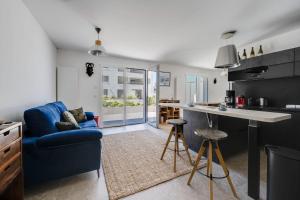sala de estar con sofá azul y cocina en Envie de Lac - Nice T3 for 6 people near Beach en Annecy