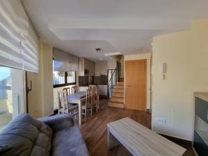 een woonkamer en een keuken met een bank en een tafel bij Foz Playa Rapadoira - 2 dormitorios in Foz