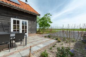 un patio con mesa y sillas frente a una casa en Langevliet 4 - Klaver 4 Callantsoog, en Callantsoog