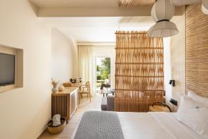a bedroom with a bed and a living room at Antigoni Seaside Resort in Ormos Panagias +37 photos