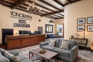 a living room with couches and a tv at Hotel Lumberjack in Sonora