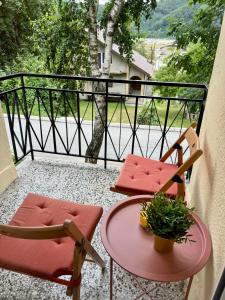 a balcony with two chairs and a table with a plant at Sunset Apartment Kolašin in Kolašin