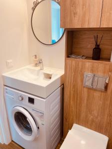 y baño con lavadora y lavamanos. en Rimos apartamentai Juodkranteje, en Juodkrantė