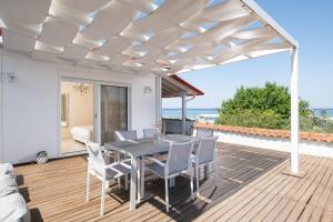 a patio with a table and chairs on a deck at Antigoni Seaside Resort in Ormos Panagias