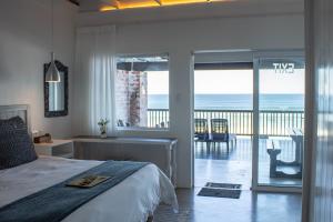 a bedroom with a bed and a view of the ocean at Seeplaas Guesthouse in Groot Brak Rivier