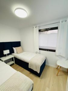 um pequeno quarto com 2 camas e uma janela em Beds Friends Apartments em Zator