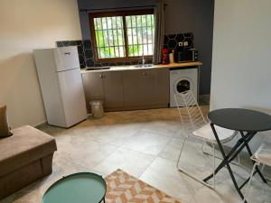 eine Küche mit einem Kühlschrank sowie einem Tisch und Stühlen in der Unterkunft LE JACQUIER Appartements neufs vue mer ou jardin à Mamoudzou Hyper Centre in Mamoudzou + 4 Fotos