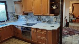 a kitchen with wooden cabinets and white counter tops at Ferienhaus an der Förde in Flensburg