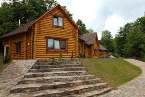 a log cabin with stairs in front of it at Recreation Complex Uzhanski Kupeli in Volosyanka