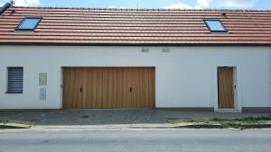 ein Haus mit zwei Garagentüren und einem Dach in der Unterkunft U Francúza in Strážnice