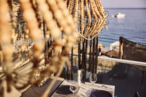 a table with wine glasses and a view of the ocean at Artemis Seaside Resort in Paliochori